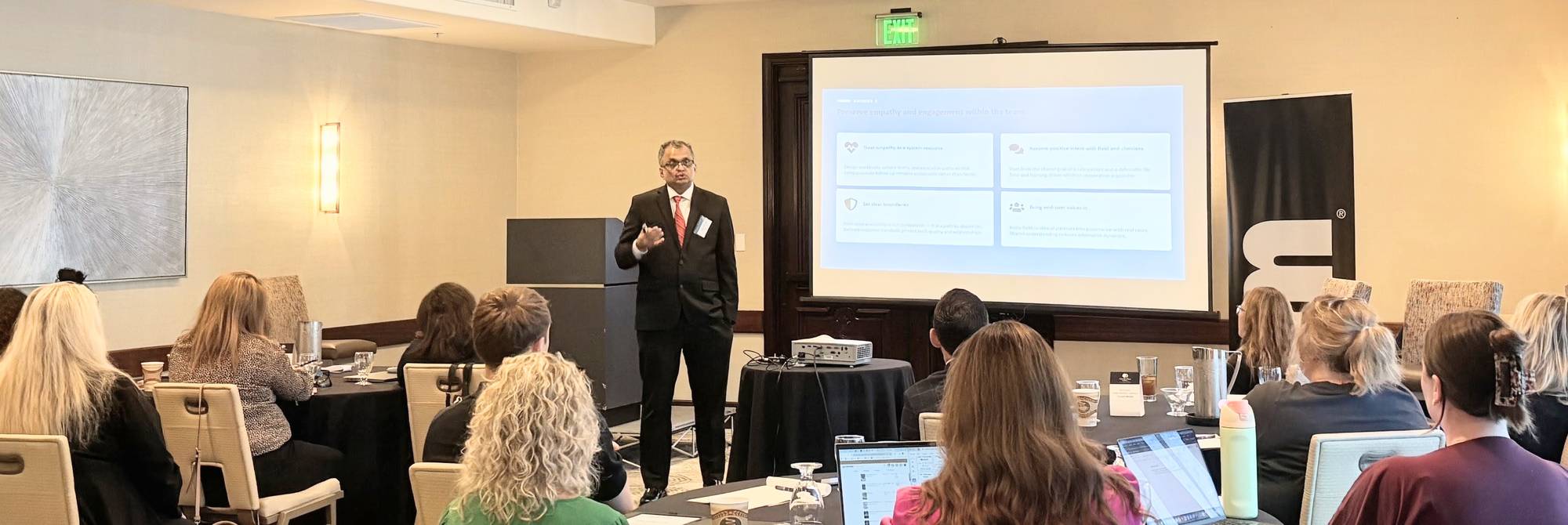 Satish Amancharla presenting to a room of colleagues